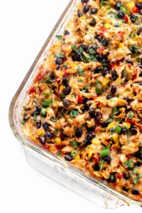 Up close shot of chicken burrito casserole in a glass baking dish.