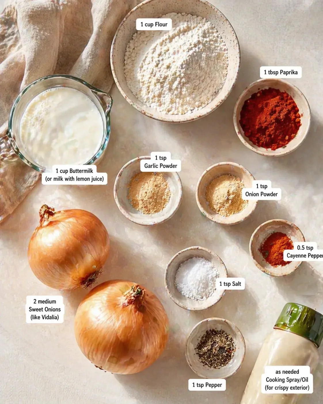 Overhead view of ingredients for crispy coating: flour, buttermilk, onions, and spices arranged in bowls.