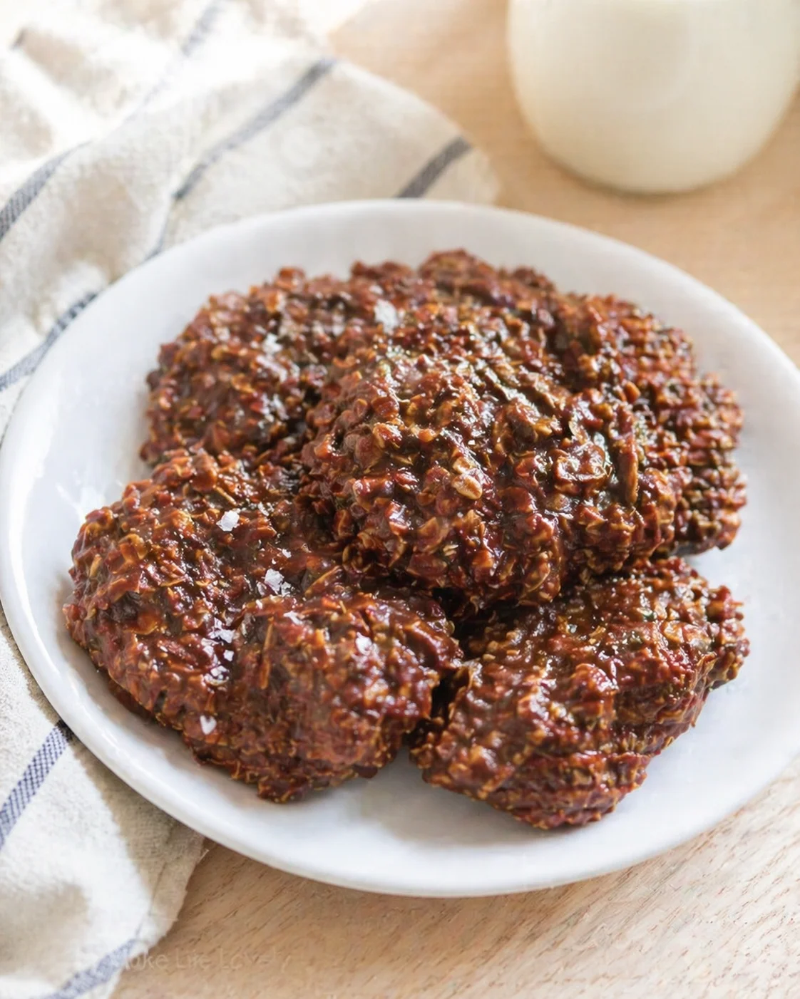 dark chocolate oatmeal bites on a white plate with a rustic wooden surface