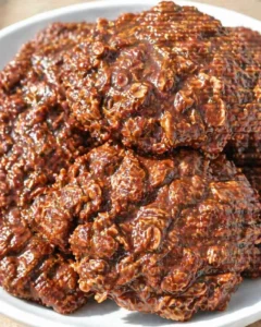 Close-up of glossy caramel oat clusters piled on a white plate.