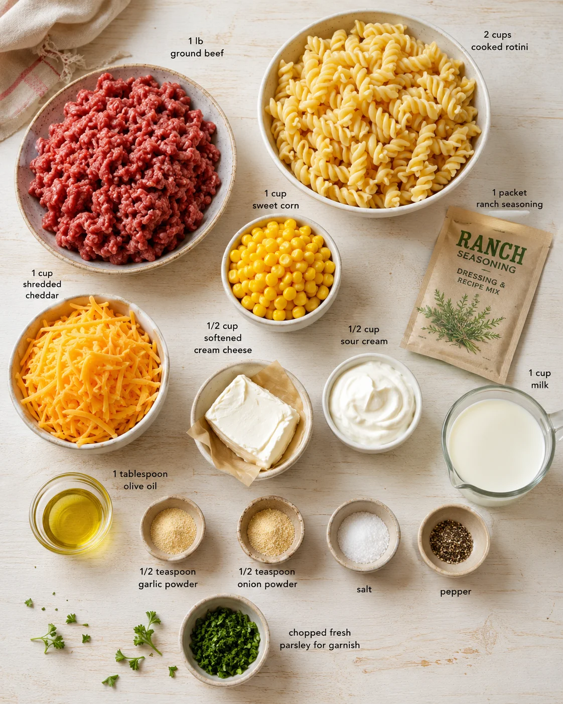 Top-down view of ingredients for a beef pasta dish, including ground beef, rotini, corn, cheese, and condiments.