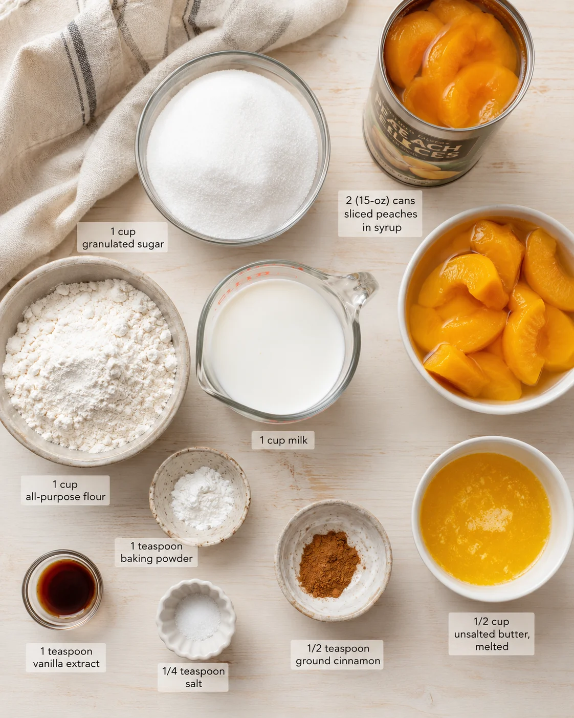Top-down view of peaches in syrup and baking ingredients on a light wood surface.