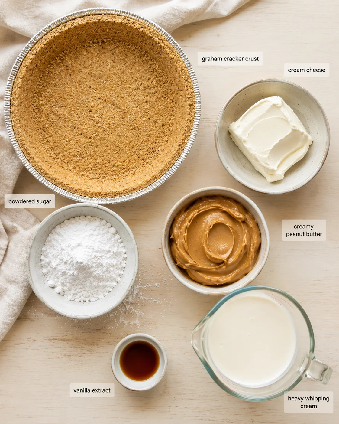 Top-down flat lay of crust, cream cheese, peanut butter, sugar, vanilla, and cream.