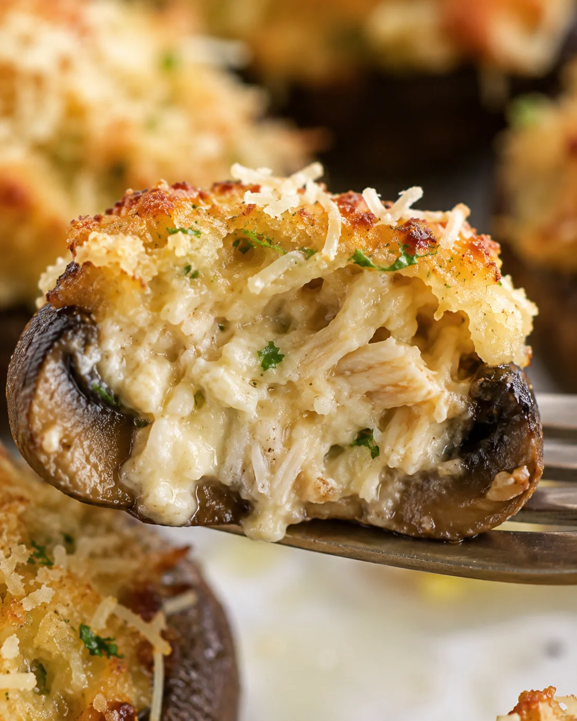 Close-up of a baked crab stuffed mushroom with creamy filling and golden topping.