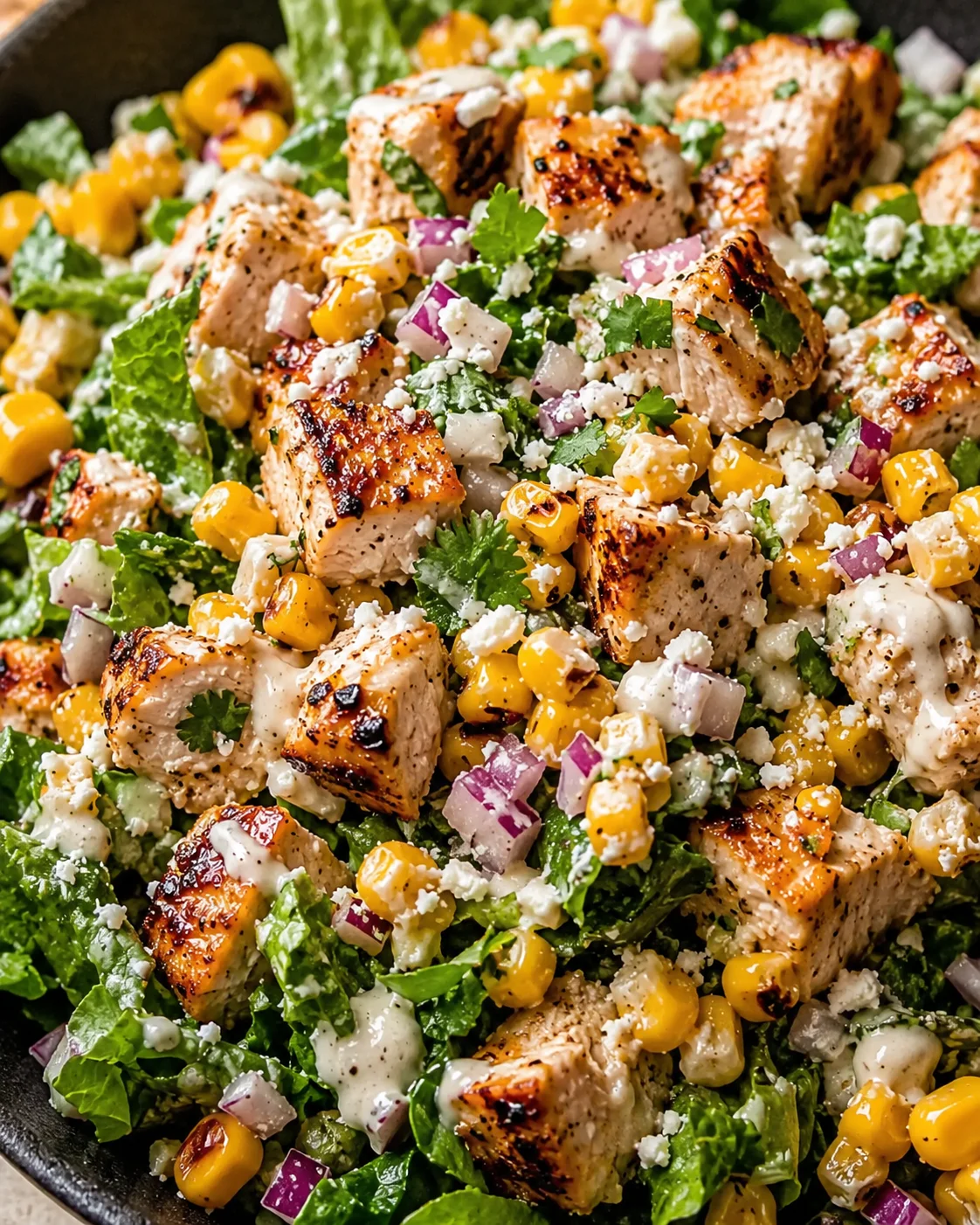 Colorful salad with grilled chicken, corn, and fresh vegetables on a plate