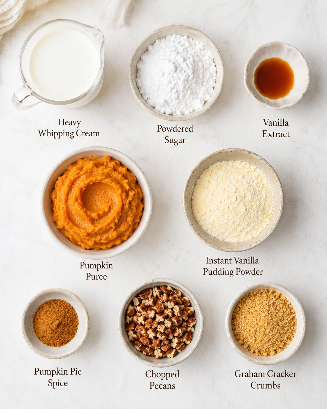 Creamy pumpkin fluff in bowls with ingredients like whipped cream and pumpkin puree.