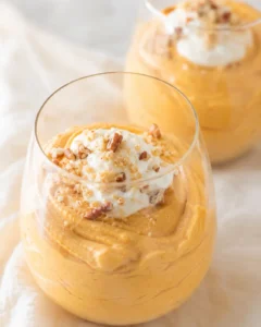 Creamy pumpkin fluff served in a glass with whipped cream and chopped nuts
