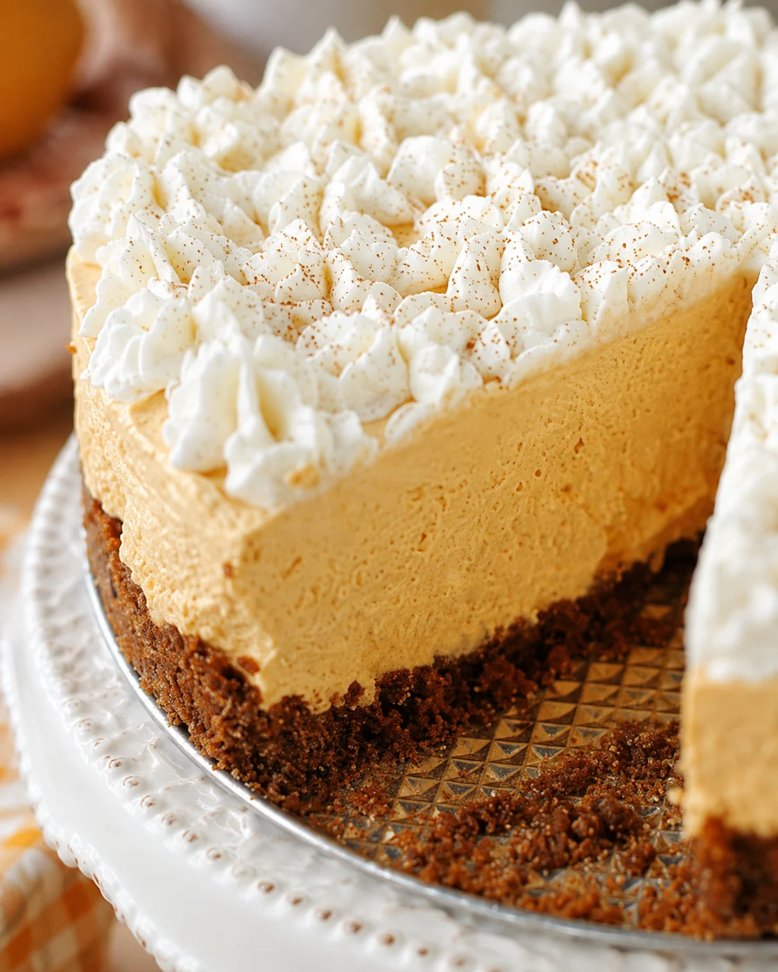Close-up of a light, fluffy pumpkin silk pie with whipped cream topping.