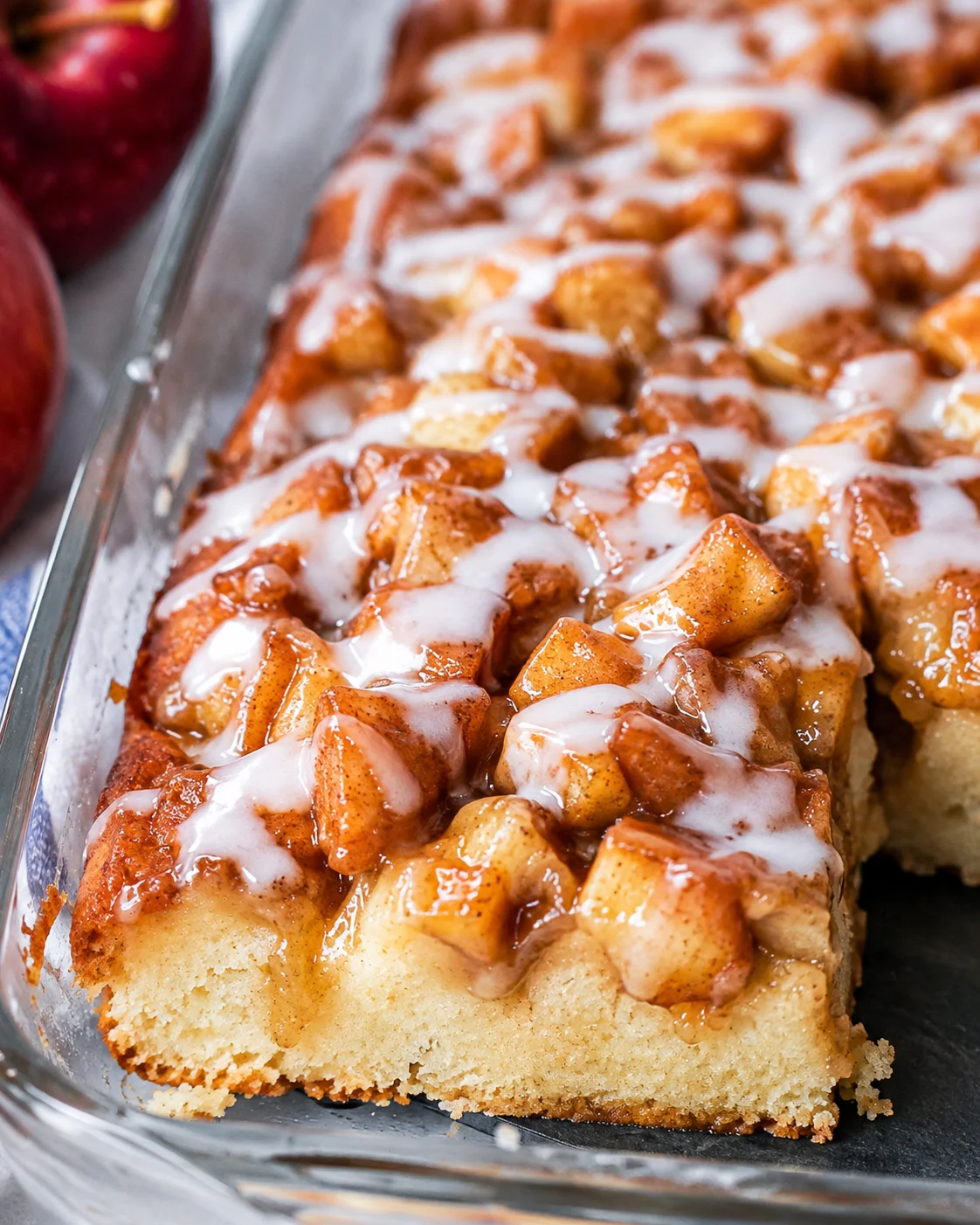 Sweet apple pie coffee cake topped with glaze and cinnamon spices, fresh out of the oven.