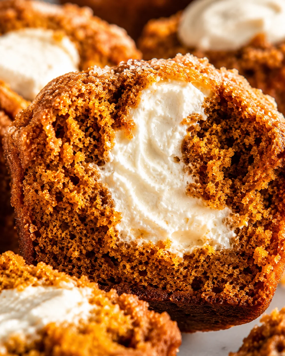 Close-up of a pumpkin muffin with creamy maple-filled center and crunchy topping